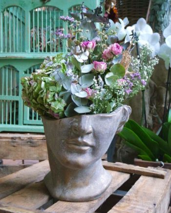 Arreglo de flor en maceta de busto griego